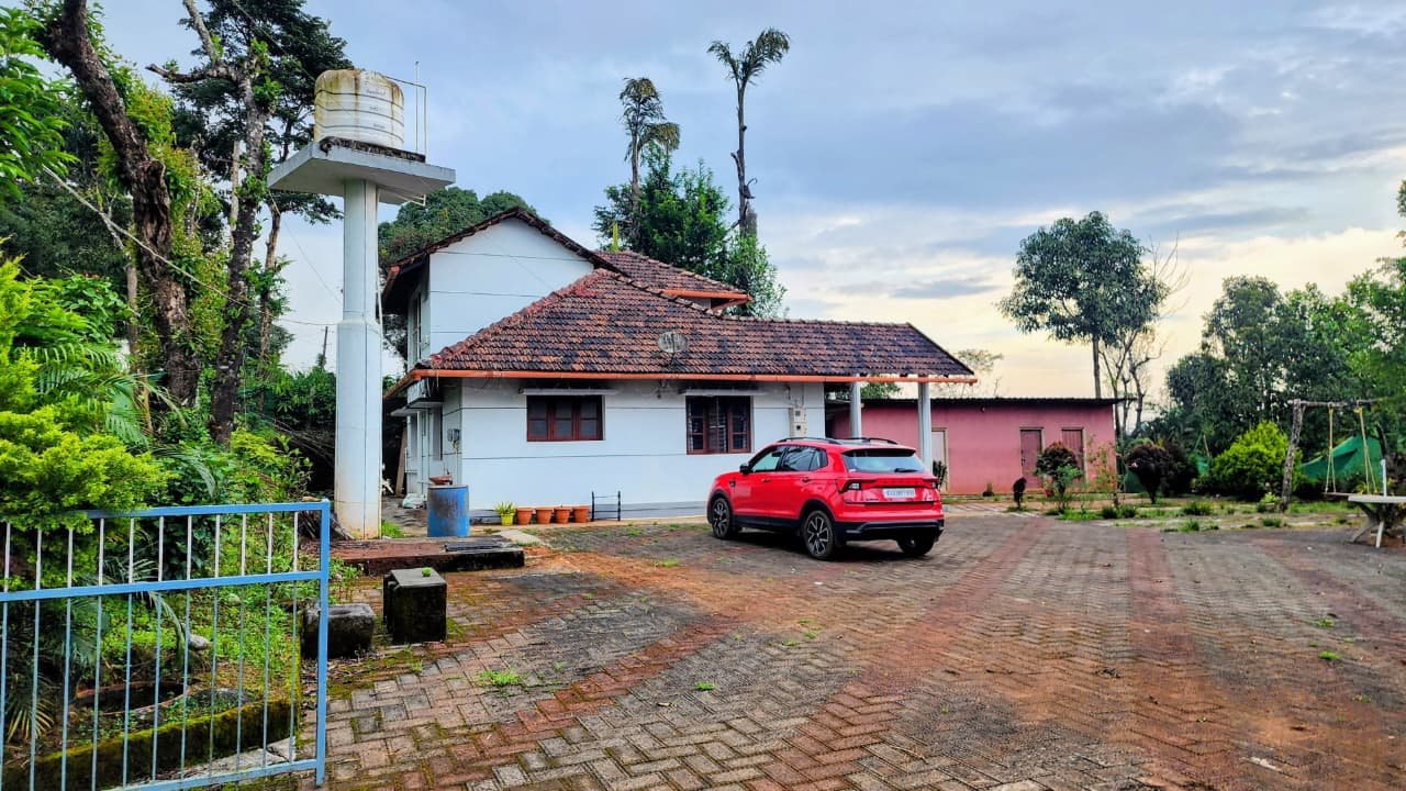 The farmhouse and open paved courtyard at dusk
